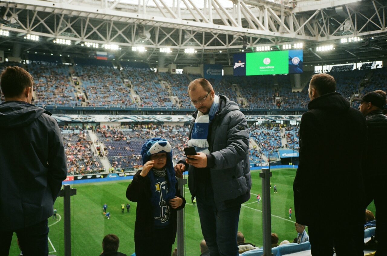 Man using phone at football match. 5G will help reduce network congestion in highly populated areas.